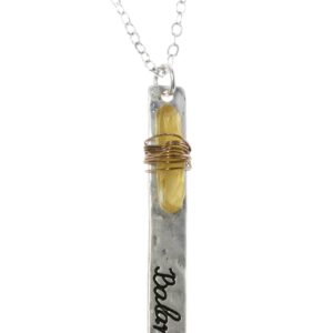 A pendant necklace featuring a cylindrical glass vial with a cork stopper and the word 'Believe' inside.