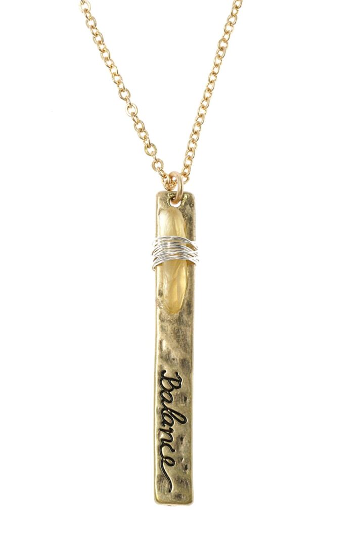 Gold pendant necklace with engraved text and a decorative ring.