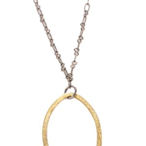 A delicate pendant necklace with a large gold oval charm on a thin silver chain.